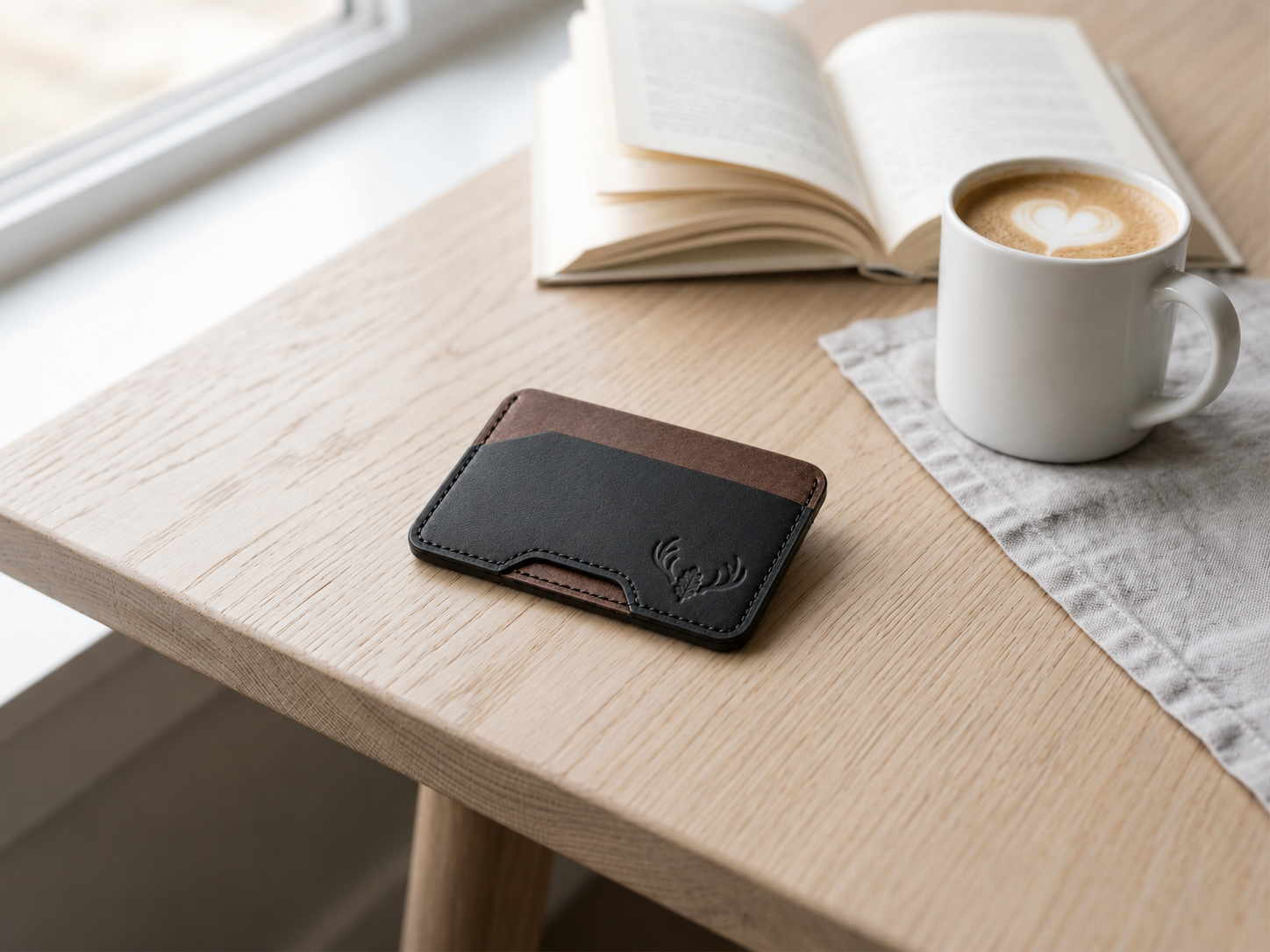 Black and walnut OB-03 minimalist card wallet beside a coffee and open book